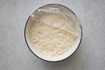 No-Knead Dutch Oven Bread, step 2: risen dough turned out onto a work surface dusted with semolina