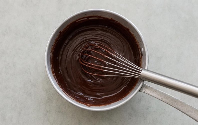 Melting the chopped dark chocolate in hot cream for the ganache