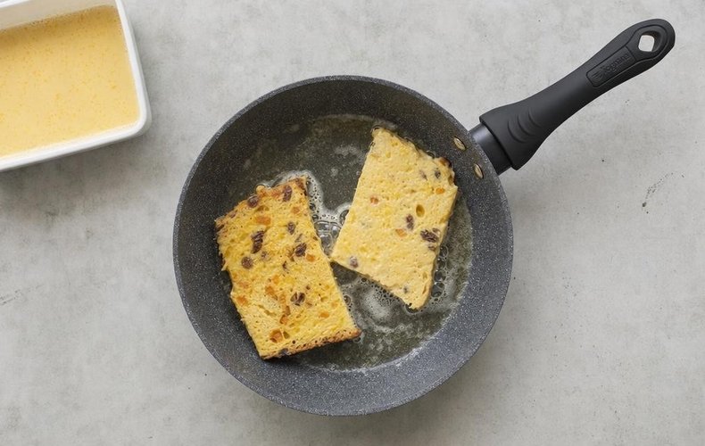 Panettone French Toast, step 3: batter-soaked panettone slices cooking in butter in a skillet