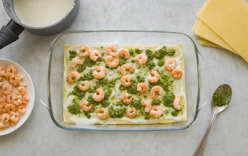 Pesto and Shrimp Lasagna, step 4: layers of pasta, béchamel, pesto and shrimp in a baking dish