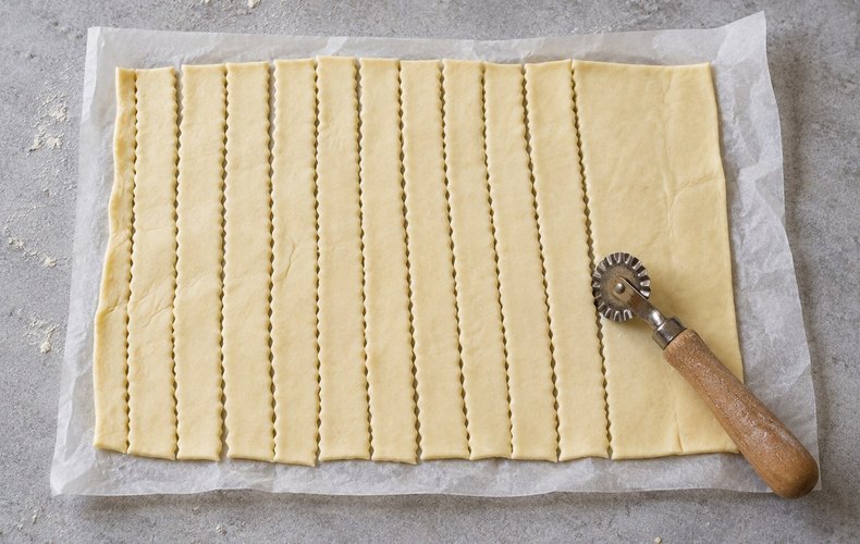 Puff Pastry Christmas Tree Place Cards, step 1: puff pastry cut into strips with a pastry wheel