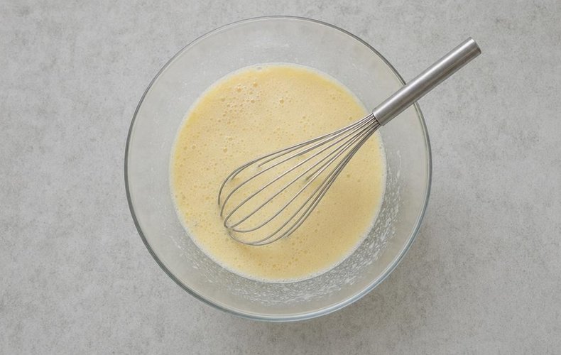 Whisking the eggs, milk, oil and yogurt until smooth