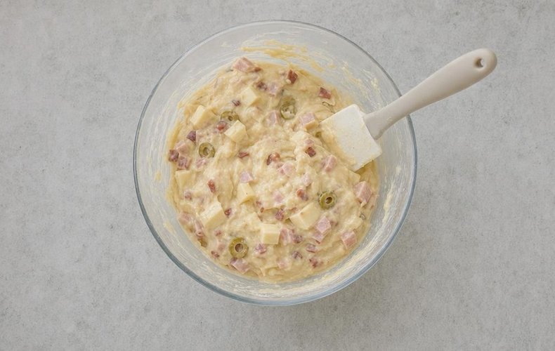 Folding the cured meat, provola and olives into the dough