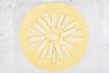 Arranging the Brie slices on the puff pastry
