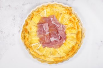 Garnishing the savory pie with salad greens