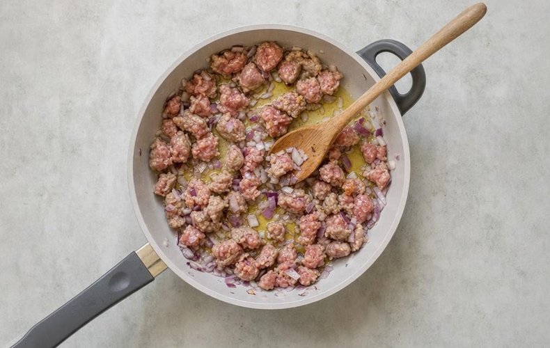 Red Wine and Sausage Risotto, step 2: browning the sausage pieces with the onion