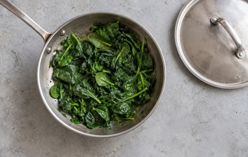 Ricotta and Spinach Caramelle, step 2: fresh spinach wilting in a skillet
