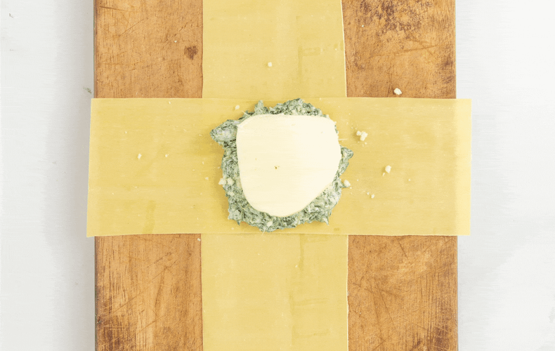 Folding the pasta strips to close a ricotta and spinach bundle