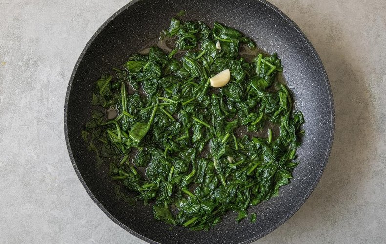 Ricotta and Spinach Puff Pastry Cups, step 1: spinach sautéed with garlic in a pan
