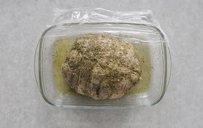 Roast Fresh Ham, step 3: the meat rubbed with herbs in a glass dish with white wine