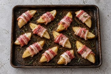 Roasted Potatoes with Pancetta, step 2: pancetta-wrapped wedges in a baking pan with oil and herbs
