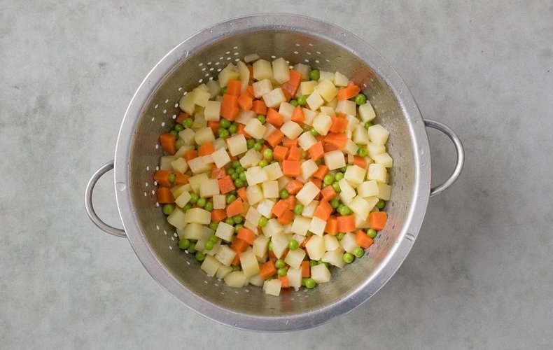 Russian Salad Tartlets, step 6: diced vegetables and peas cooking in a pot