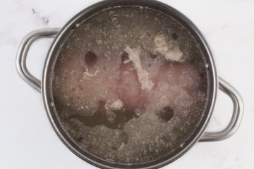 Salame cotto simmering in a pot of water