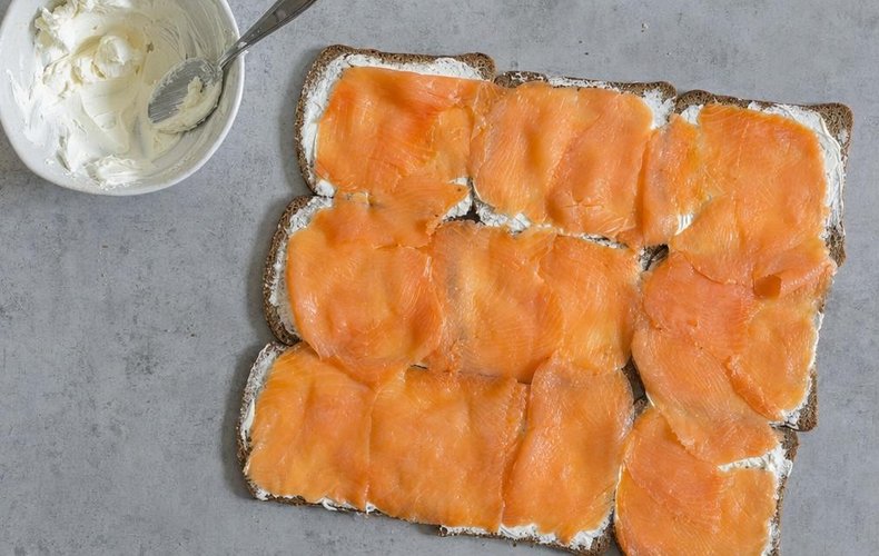 Salmon and cream cheese pinwheels, step 1: rye bread topped with smoked salmon and lemon cream cheese