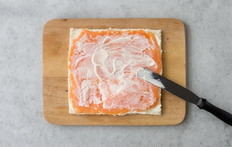 Salmon and Pistachio Tramezzini Christmas Trees, step 2: smoked salmon laid over the cream cheese on the bread