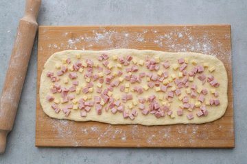 Savory Bread Wreath, step 3: rolling the dough around the ham and Emmental