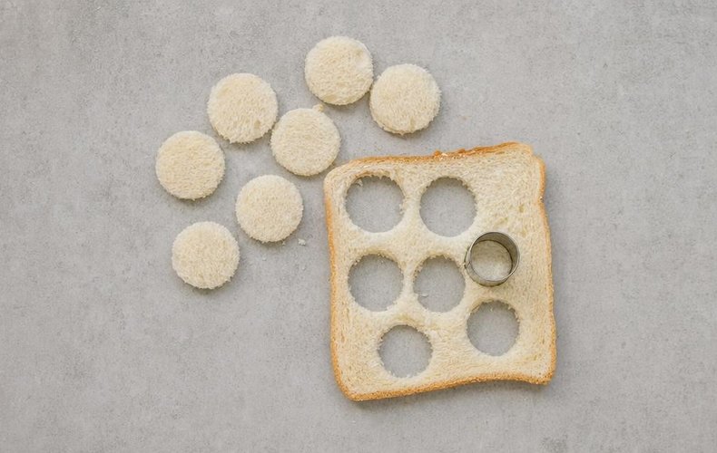 Cutting small circles from a slice of sandwich bread