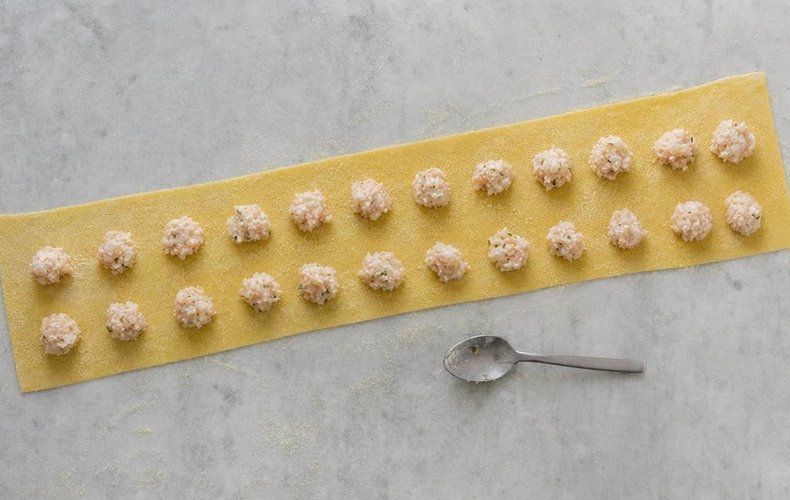 Two rows of filling on a sheet of fresh pasta