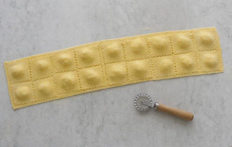 Cutting the ravioli with a fluted pastry wheel