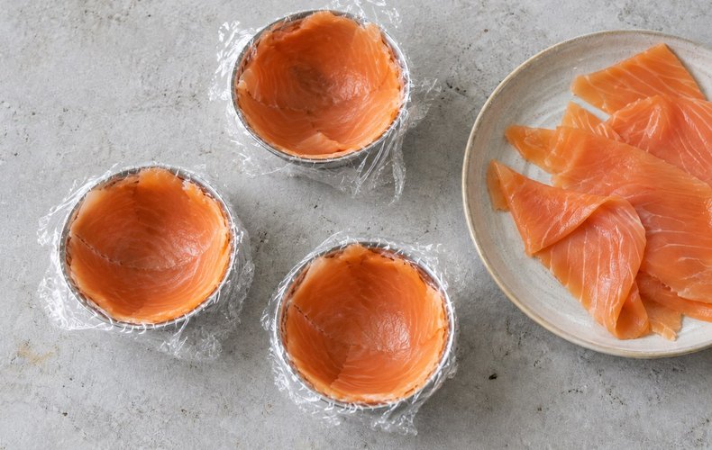 Lining the half-sphere molds with smoked salmon