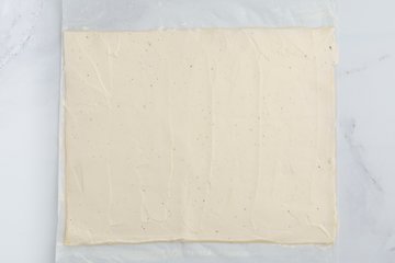 Spreading the cream cheese over the puff pastry