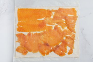 Layering smoked salmon over the cream cheese