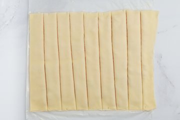 Cutting the pastry into strips with a pizza cutter
