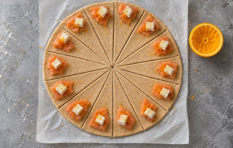 Smoked Salmon Puff Pastry Crescents, step 3: smoked salmon, orange zest and Brie on each triangle