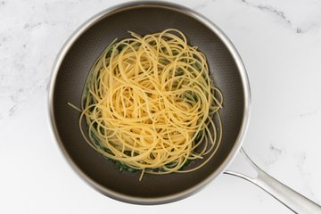 Spaghetti finishing cooking in the clam sauce