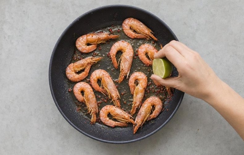 Spinach Tagliatelle with Shrimp, step 3: jumbo shrimp cooking in a pan with pink peppercorns