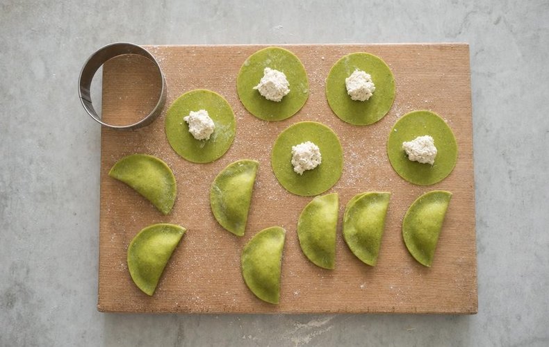 Spinach Tortelli with Ricotta and Parmigiano, step 7: rounds of green pasta filled and folded into half-moons