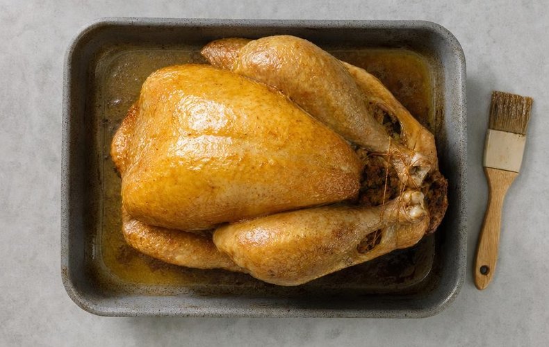 Stuffed Christmas Turkey, step 5: the turkey brushed with butter in a baking dish