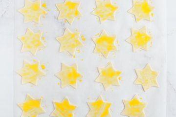 Brushing the stars with egg yolk and sprinkling with sesame seeds