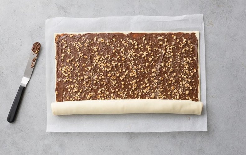 Super Quick Nutella Brioches, step 2: spreading Nutella and chopped hazelnuts on the pastry