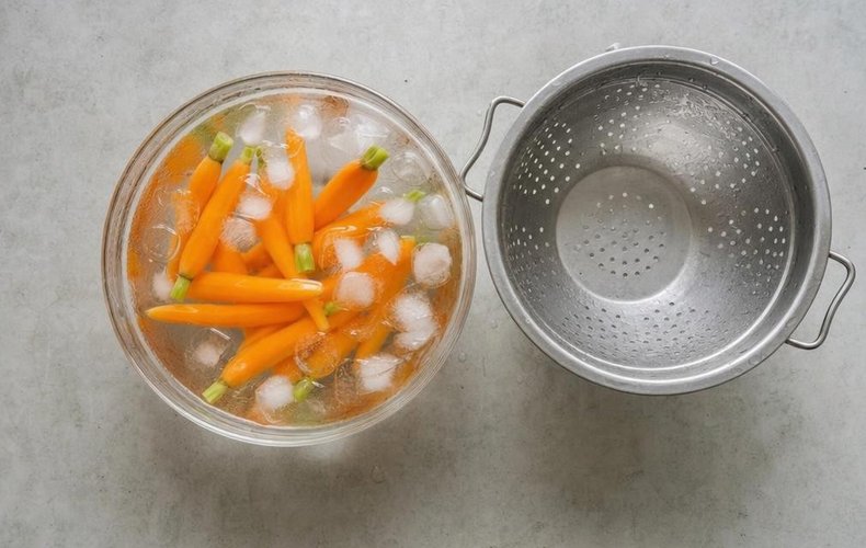 Thyme-Glazed Baby Carrots, step 2: blanched carrots cooling in a bowl of ice water