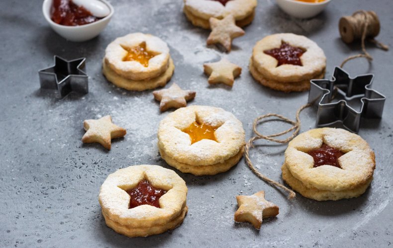 Tyrolean jam cookies dusted with powdered sugar on a serving tray