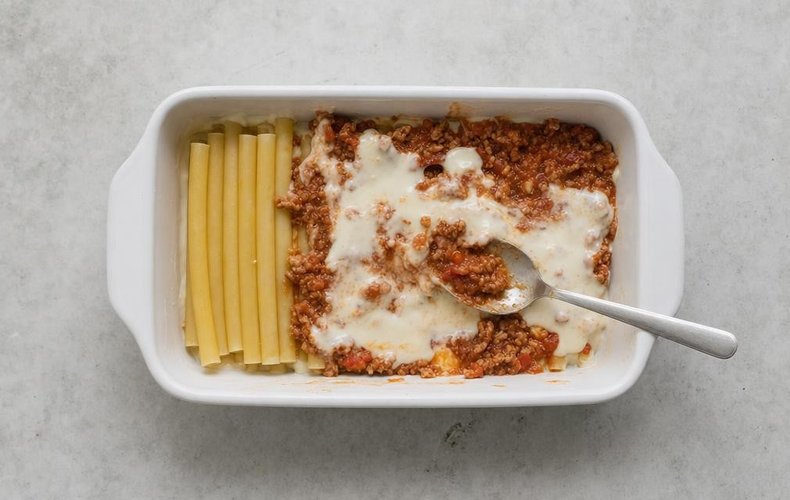 Ziti Lasagna, step 4: layers of ziti, ragù and béchamel in a baking dish